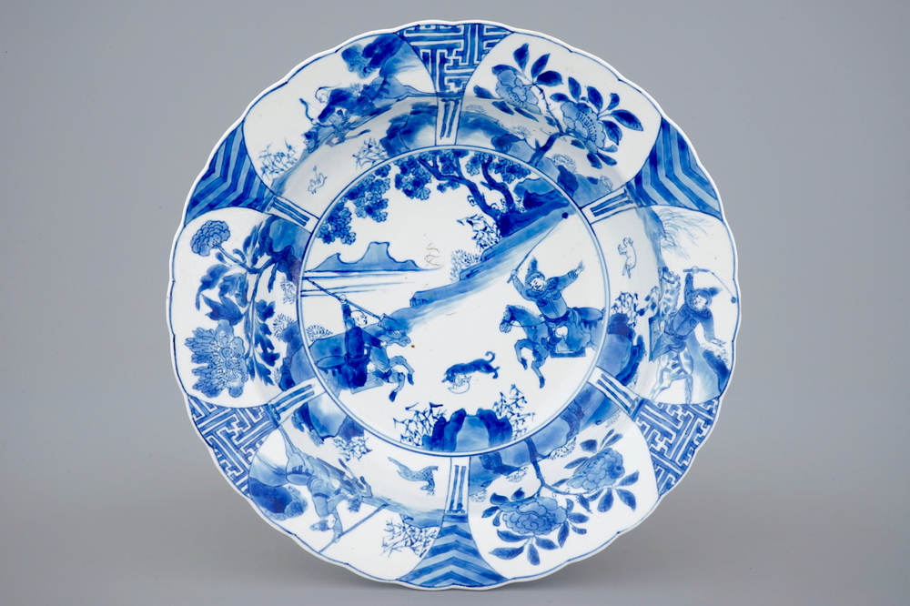 Een diep Chinees blauw-wit bord met strijdende rijders, Kangxi