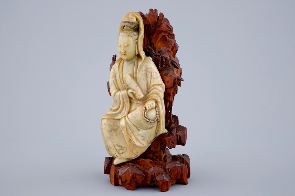 Une figure de Guanyin en pierre de savon sur socle en bois sculpt&eacute;, 18/19&egrave;me