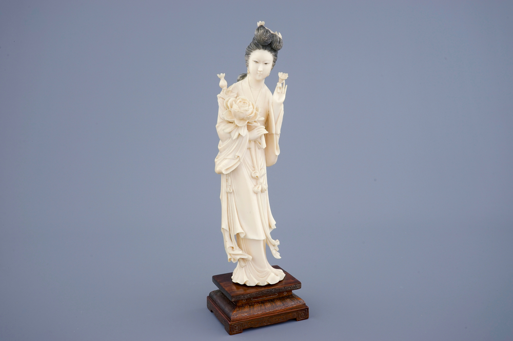 Een grote Chinese ivoren figuur van Guanyin op houten sokkel, begin 20e eeuw