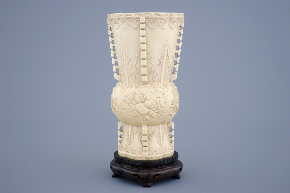 Un vase en ivoire sculpt&eacute; d'apr&egrave;s un mod&egrave;le archa&iuml;que sur socle en bois, 19&egrave;me