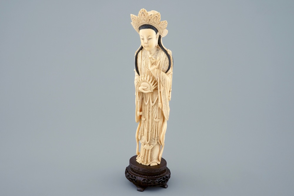 Une figure de Guanyin en ivoire sculpt&eacute; sur socle en bois, d&eacute;but du 20&egrave;me