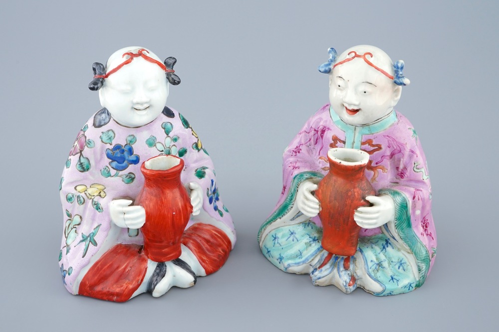 Een paar Chinese famille rose figuren van zittende jongens met een vaas, 18/19e eeuw