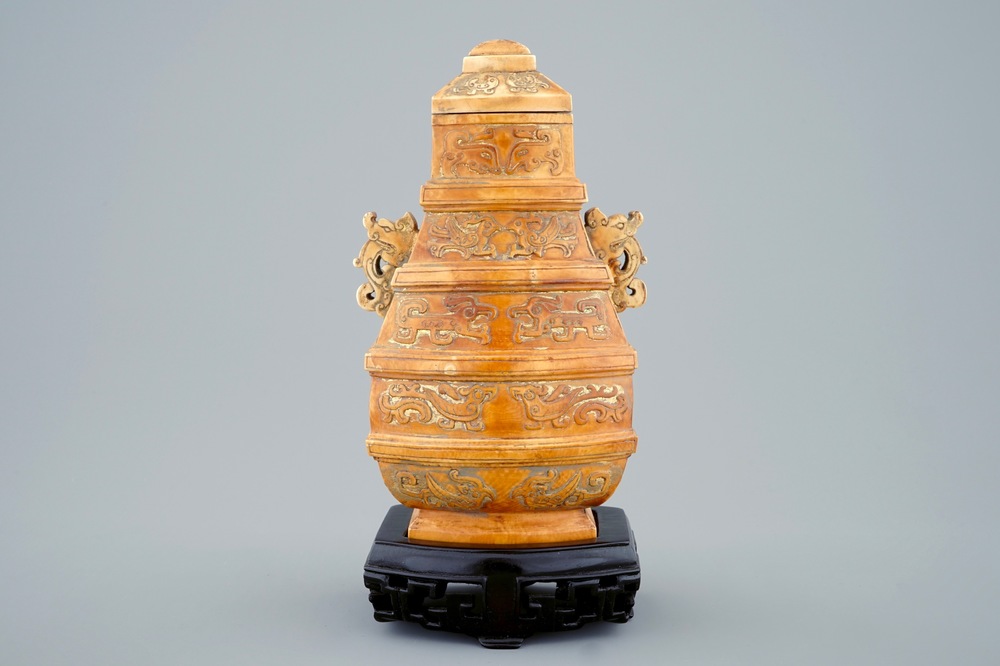A Chinese parcel-gilt ivory vase and cover on wooden stand, 19th C.