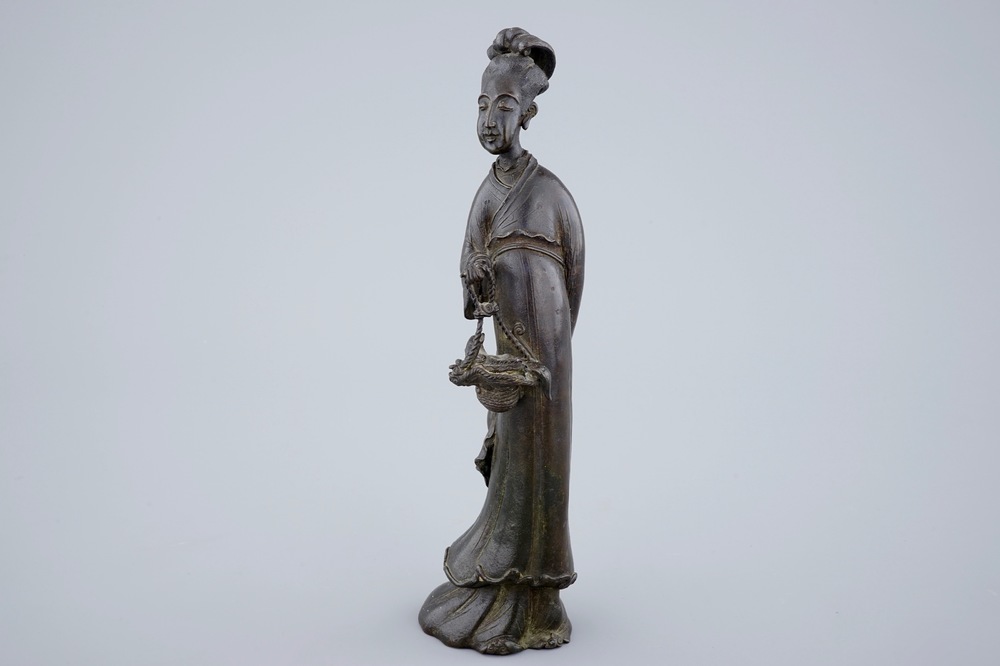 A Chinese bronze figure of a lady with a flower basket, 18/19th C.