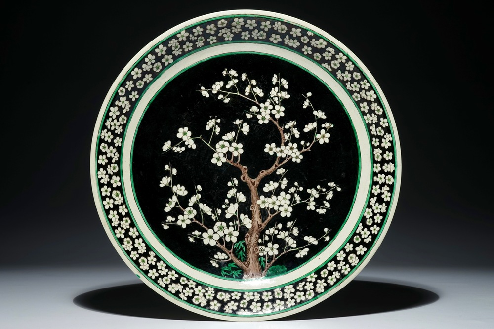 A Chinese famille noire on biscuit prunus tree charger, Kangxi