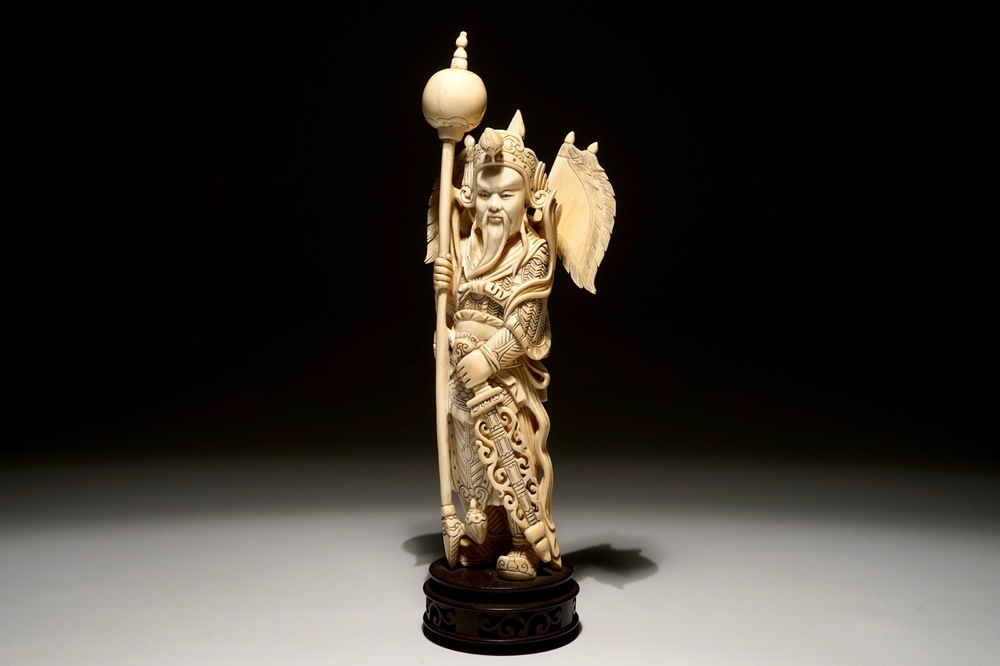 A Chinese carved ivory figure of a warrior on a wooden base, late 19th C.