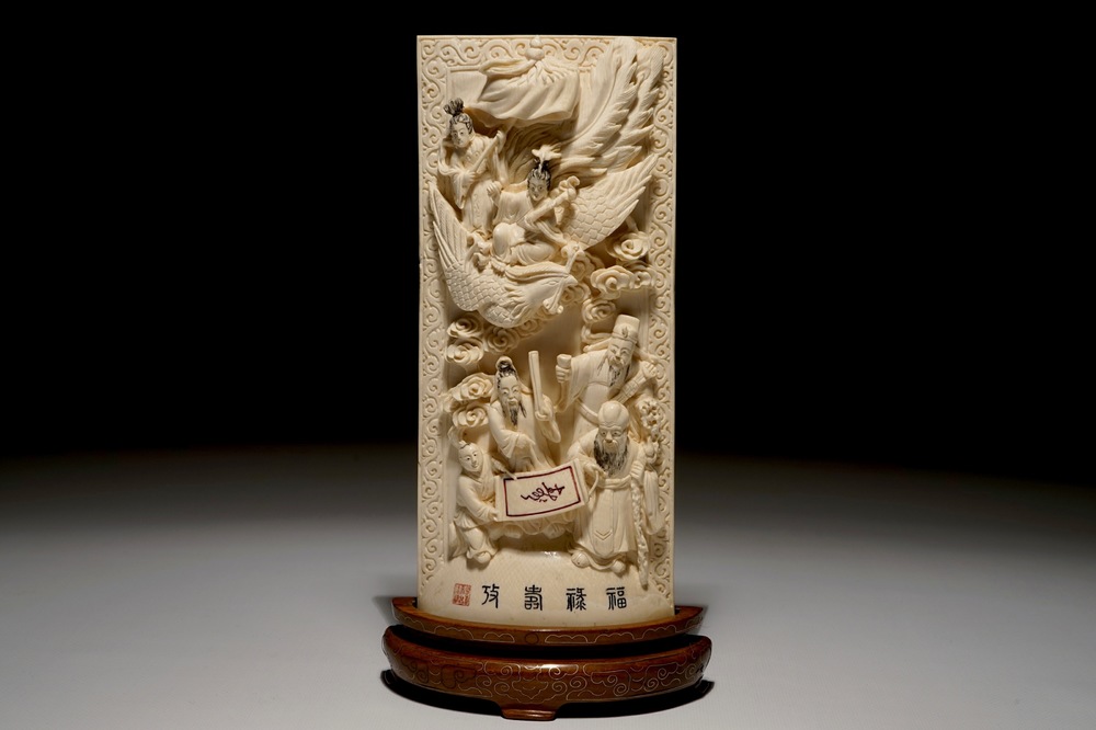 A Chinese carved ivory plaque with immortals on wooden stand, 2nd quarter 20th C.