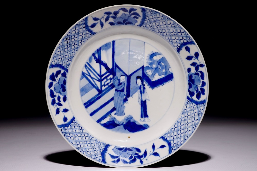 Een Chinees blauw-wit bord met figuren in een tuin, Kangxi&nbsp;merk en periode