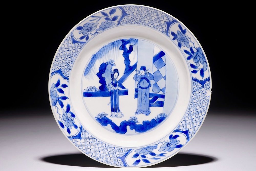 Een Chinees blauw-wit bord met figuren in een tuin, Kangxi&nbsp;merk en periode