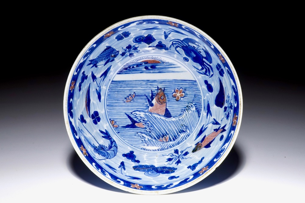 Un bol en porcelaine de Chine bleu, blanc et rouge de cuivre aux carpes et cr&eacute;atures marines, marque et &eacute;poque de Kangxi