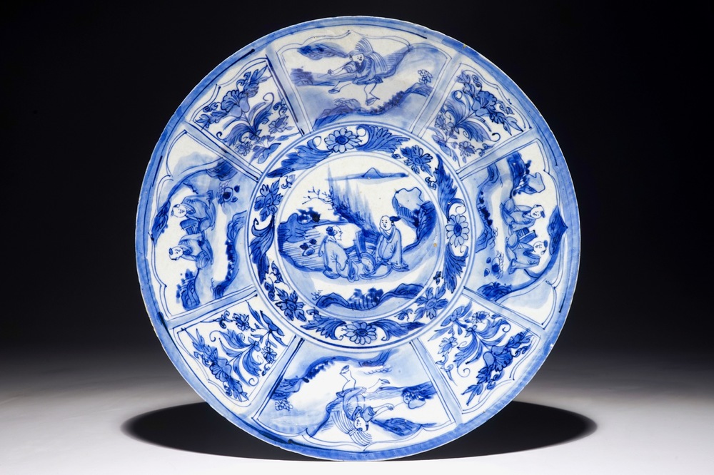 Un plat en porcelaine de Chine bleu et blanc &agrave; d&eacute;cor de figures dans un paysage, &eacute;poque Transition