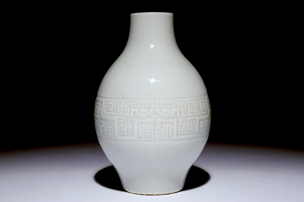 A Chinese monochrome white-glazed olive-shaped vase with underglaze design, Qianlong mark,  19th C.