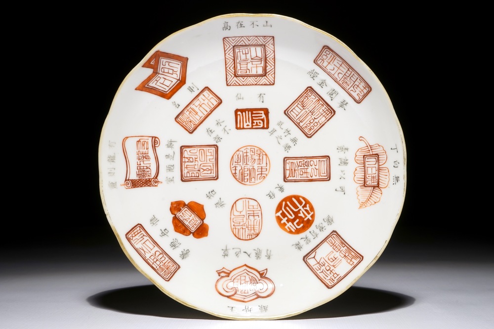 Une assiette en porcelaine de Chine &agrave; d&eacute;cor de calligraphie et marques en rouge de fer et noir, 19/20&egrave;me