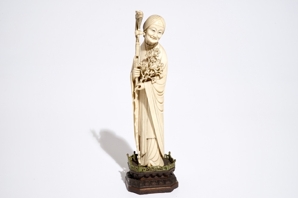 A Chinese ivory model of a lady on wooden base, 19th C.