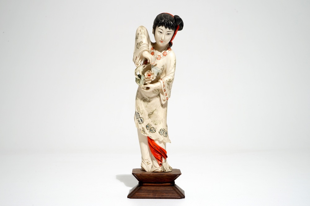 A Chinese polychrome ivory figure on wooden stand, 2nd quarter 20th C.