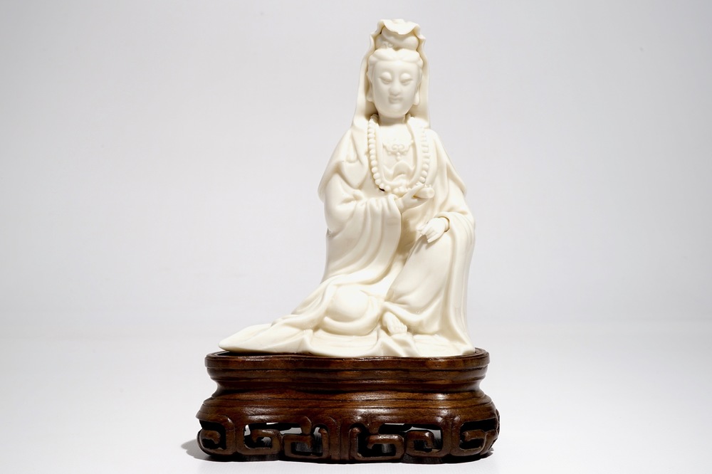 A Chinese Dehua blanc de Chine Guanyin on wooden stand, Kangxi