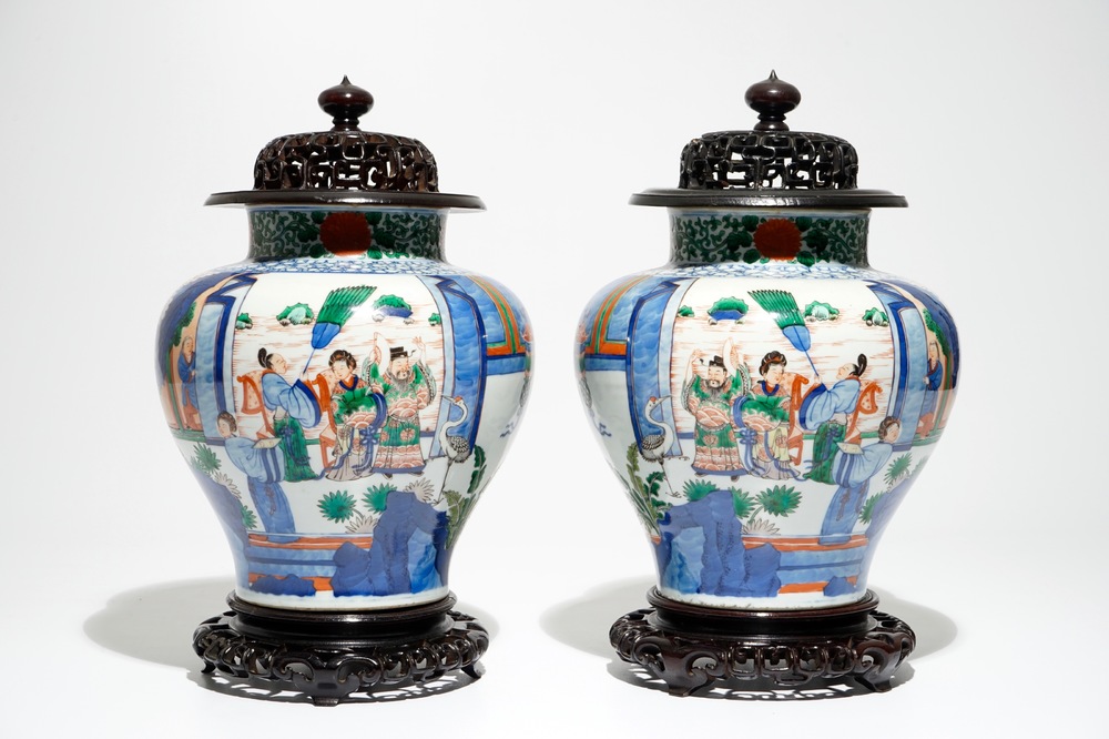 A pair of Chinese wucai baluster vases with carved lids and bases, 19th C.
