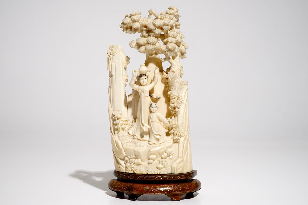 A Chinese ivory group on wooden stand, 2nd quarter 20th C.