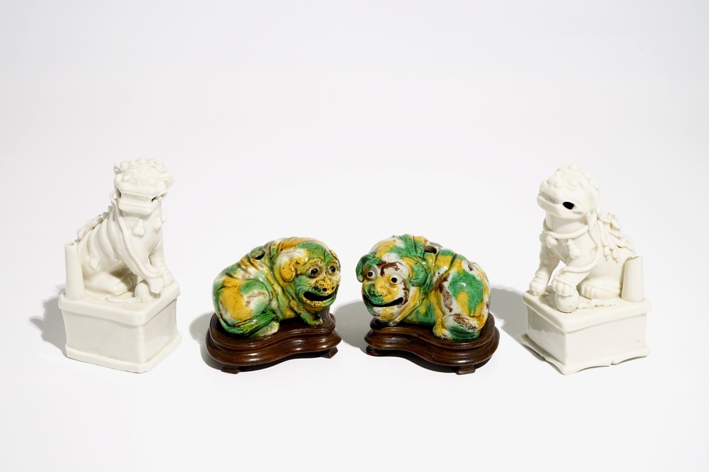 A pair of Chinese Dehua blanc de Chine Buddhist lion joss stick holders and a pair of verte biscuit dogs, Kangxi