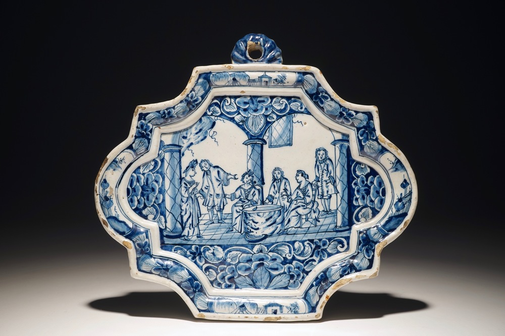 A Dutch Delft blue and white plaque with a tasting scene, 18th C.