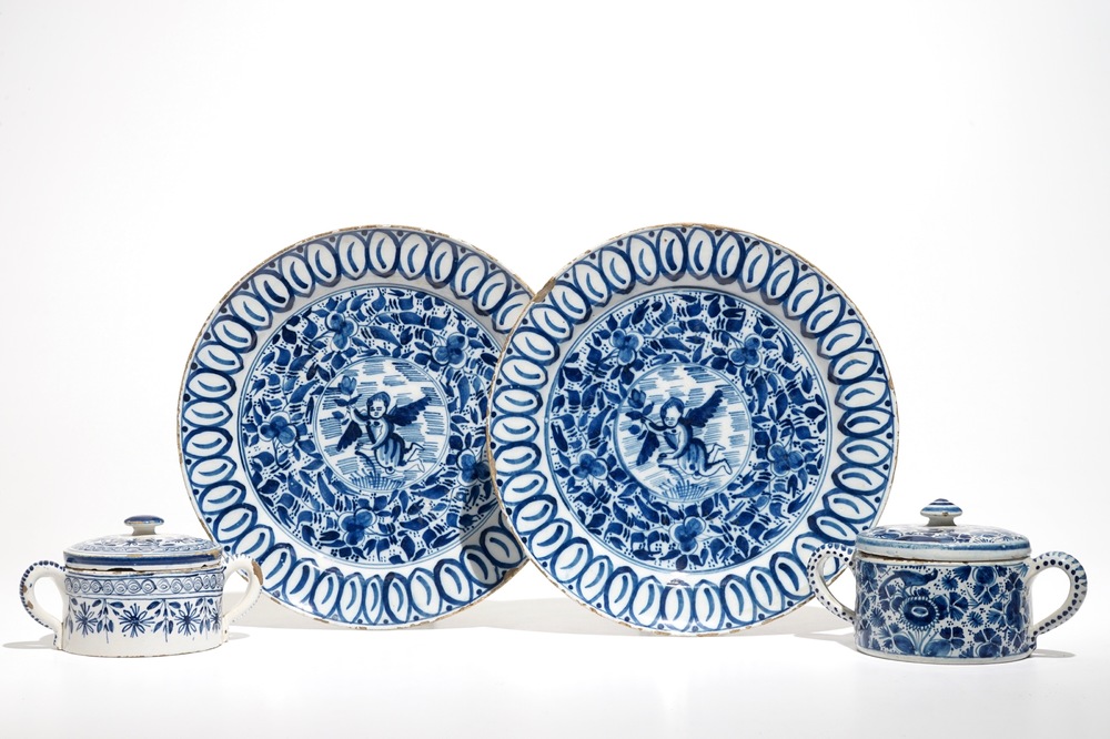 A pair of Dutch Delft blue and white dishes with cherubs and two sugar pots, 18th C.