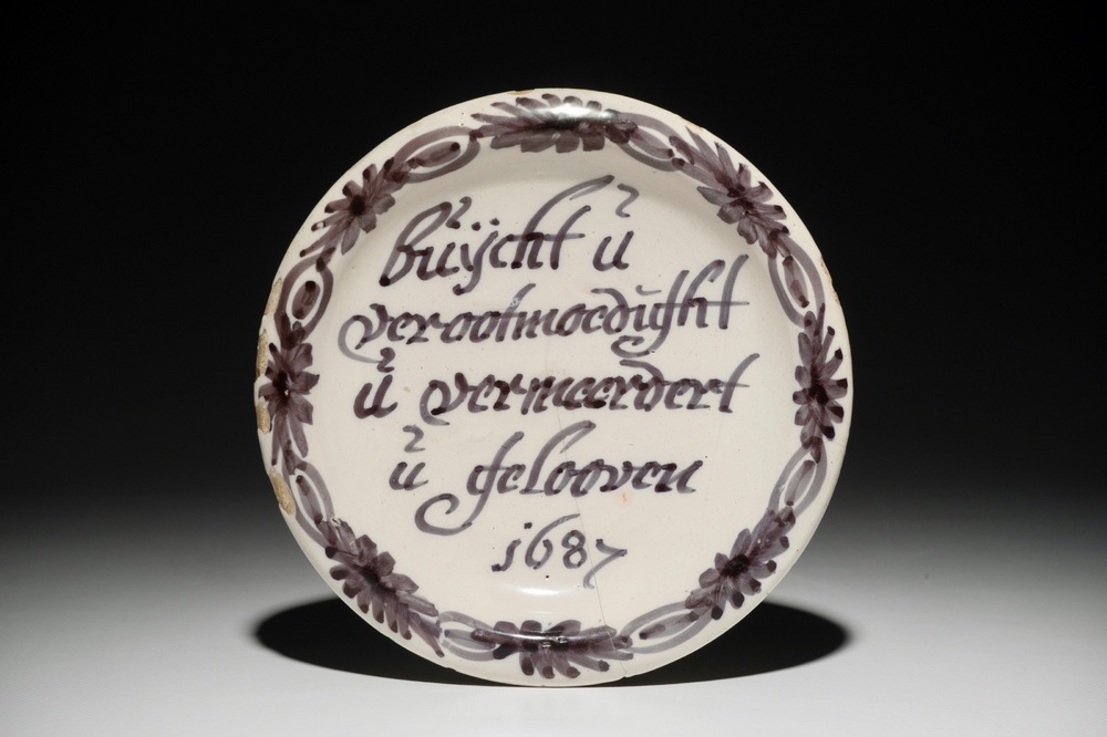 Een blauwwit Delfts spreukbord, gedateerd 1687