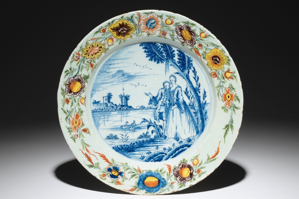 Un plat en fa&iuml;ence de Delft polychrome &agrave; technique mixte &agrave; d&eacute;cor d'une sc&egrave;ne galante, 18&egrave;me