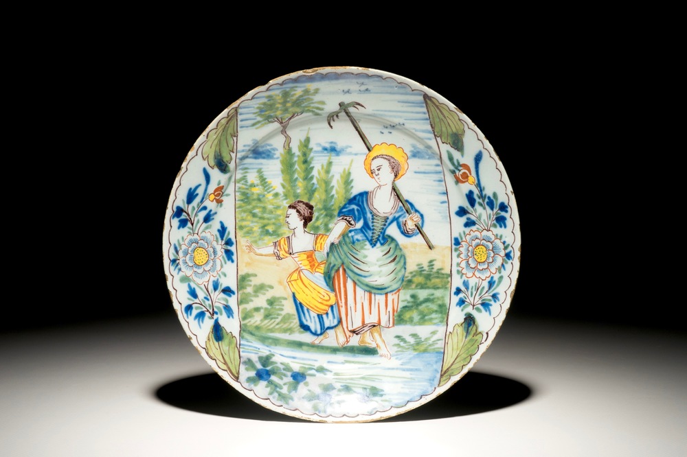 A polychrome Dutch Delft plate with a gardening lady and her daughter, 18th C.