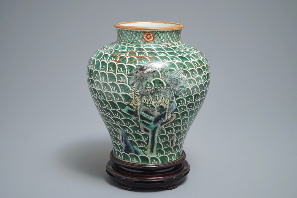 A Chinese famille verte vase with mythical beasts on a ground of waves, 19th C.
