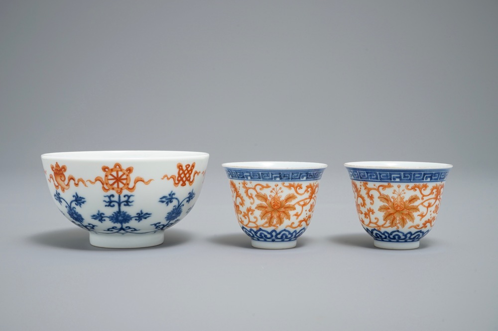 A pair of Chinese iron red and blue cups and a bowl, Qianlong and Guangxu marks, 19/20th C.