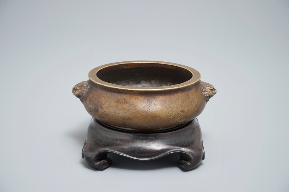 Een Chinese bronzen wierookbrander op houten voet, Xuande merk, 18e eeuw