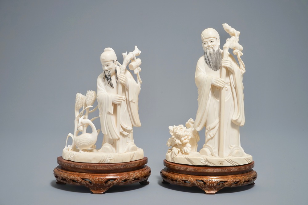 Two Chinese carved ivory figures of sages on wooden stands, 1st half 20th C.