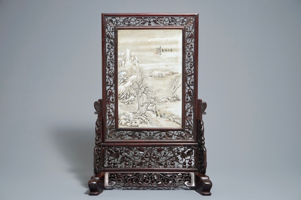 Un &eacute;cran de table en bois sculpt&eacute; mont&eacute; d'une plaque &agrave; d&eacute;cor d'un paysage hivernale d'apr&egrave;s He Xuren, 20&egrave;me
