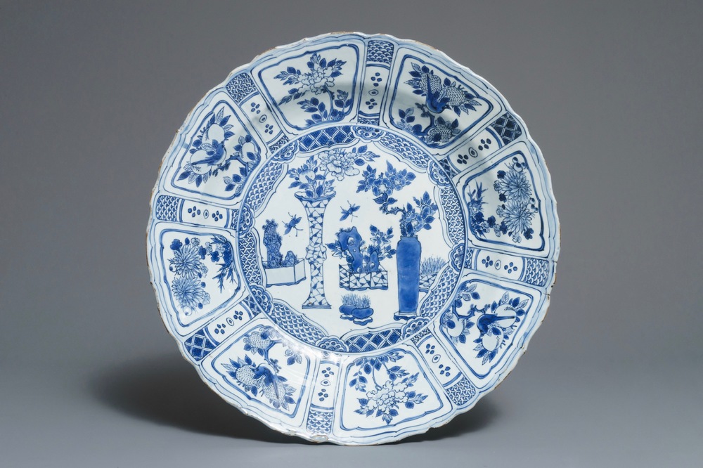 Un grand plat en porcelaine de Chine bleu et blanc de type kraak &agrave; d&eacute;cor d'un arrangement de vases, Wanli