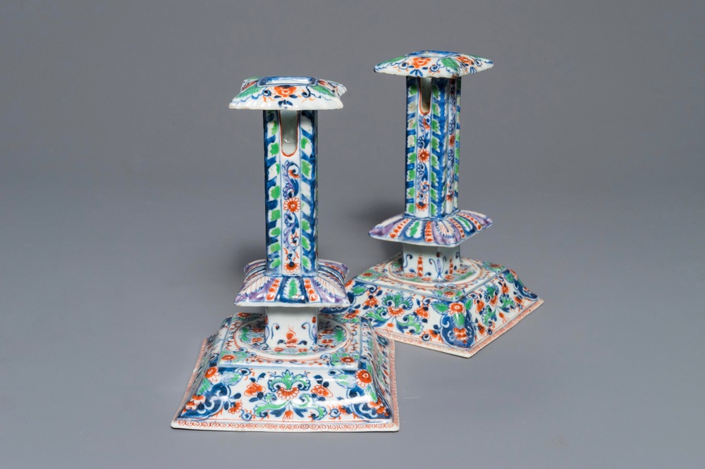 A pair of clobbered Chinese blue and white candlesticks, Kangxi