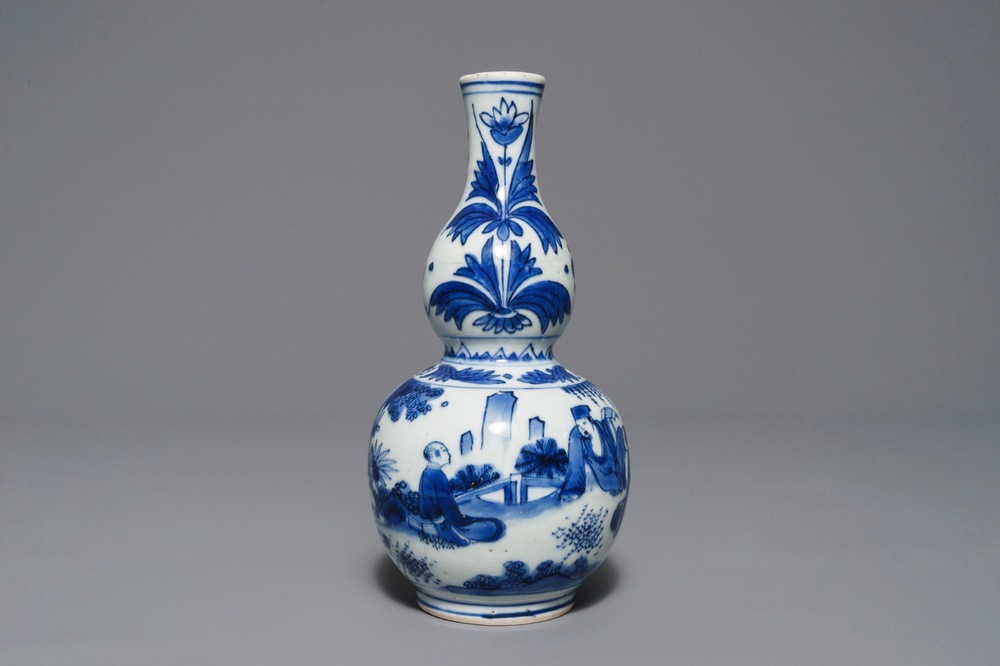 A Chinese blue and white double gourd vase with figures in a landscape, Transitional period