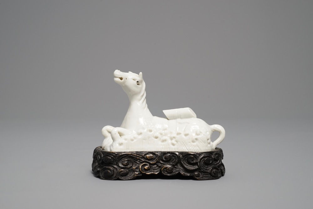Un mod&egrave;le d'un cheval en porcelaine blanc de Chine de Dehua sur socle sculpt&eacute;, Kangxi