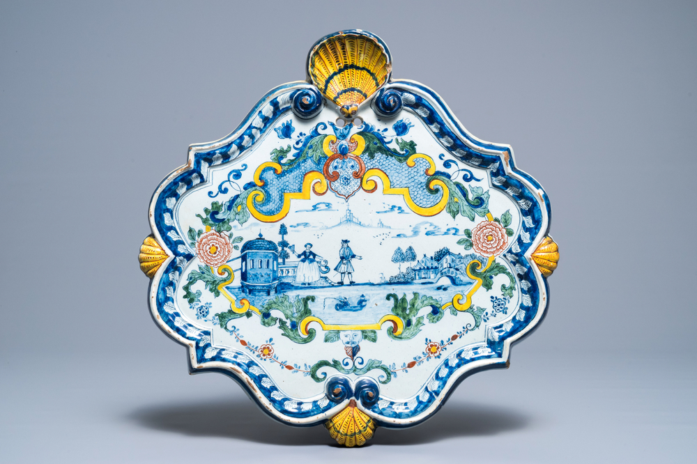 Een grote polychrome Delftse plaquette met een koppel bij een rivier, 18e eeuw