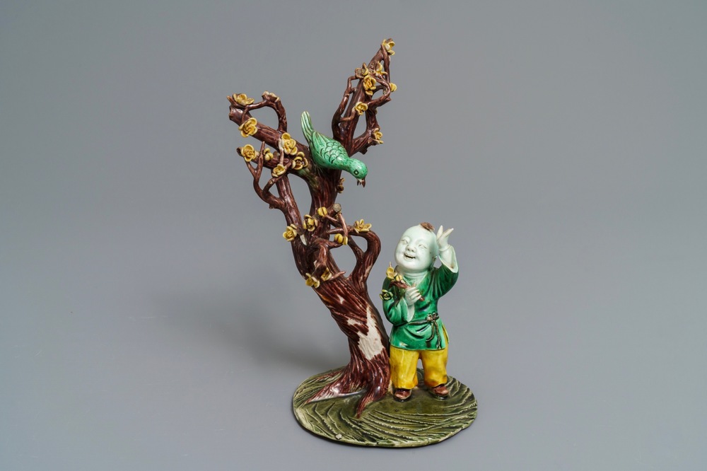 A Chinese verte biscuit group with a boy near a blossoming tree, Kangxi