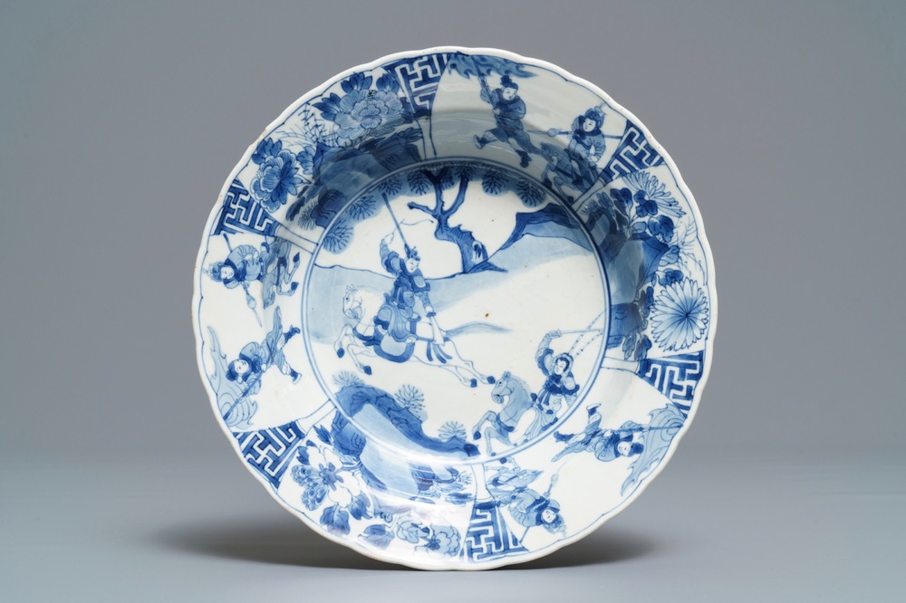 Een Chinees blauwwit bord met strijders te paard, Kangxi merk en periode