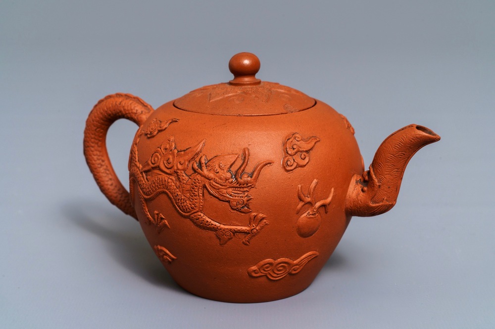 Een Chinese Yixing steengoed theepot met reli&euml;fdecor van draken, Kangxi