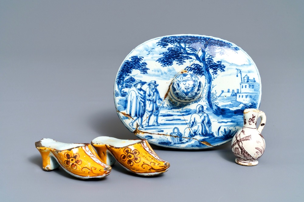 A pair of Dutch Delft polychrome slippers, a miniature jug and a fine lid, 18th C.