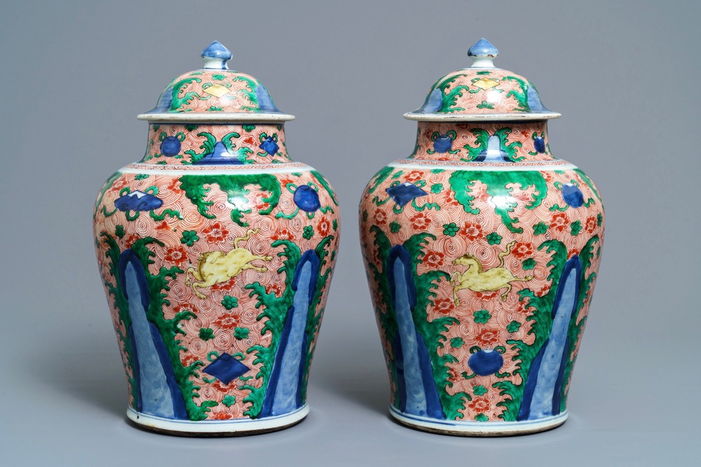 A pair of Chinese wucai 'galloping horses' vases and covers, Transitional period