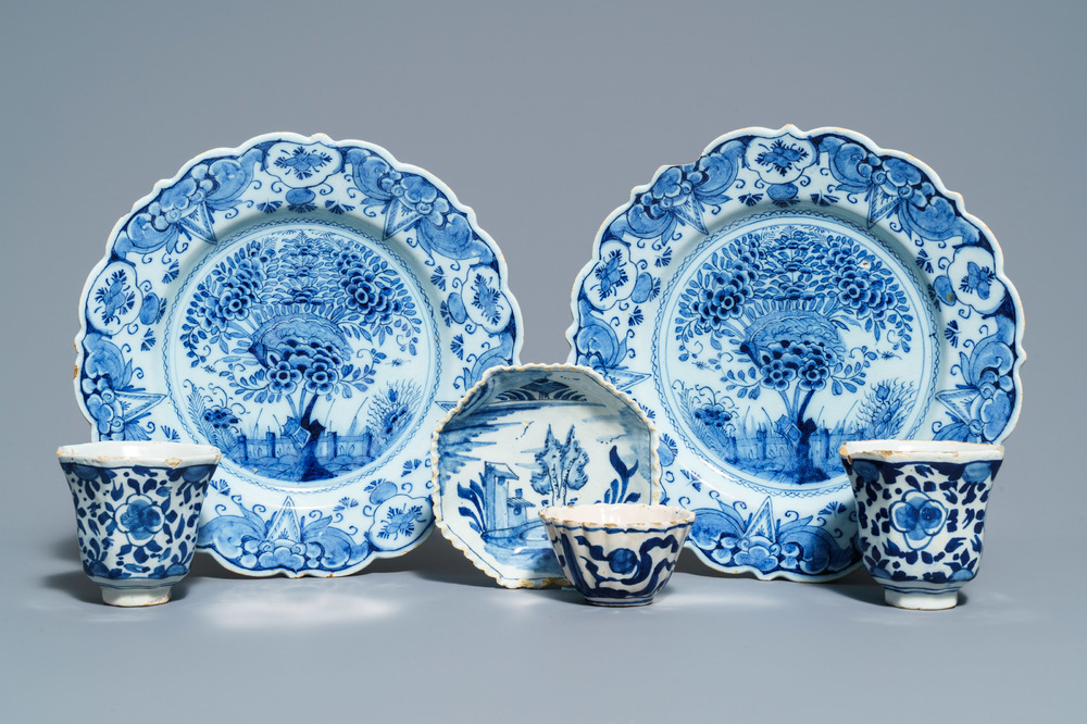 A pair of Dutch Delft blue and white plates, three cups and a saucer, 18th C.