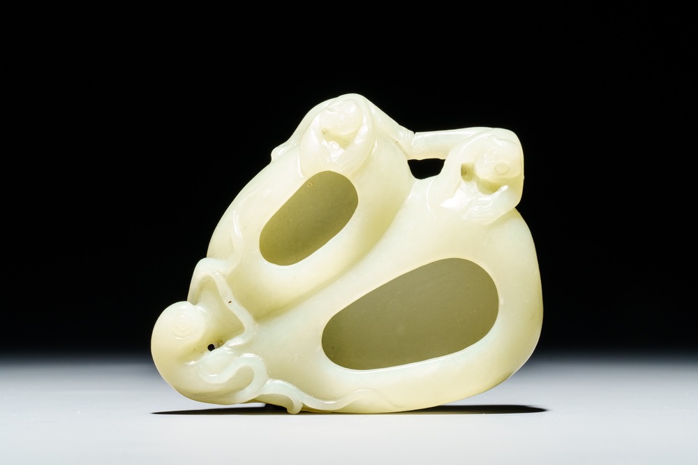 A Chinese celadon jade brush washer with monkeys on peaches, 19/20th C.