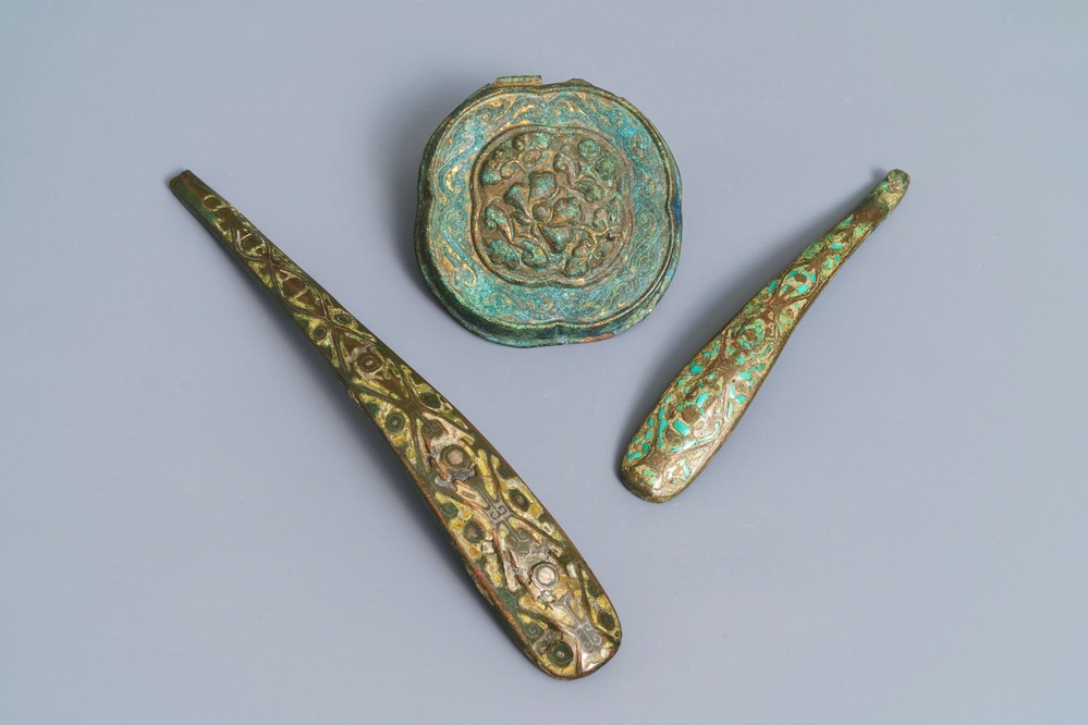 Two Chinese inlaid bronze belt hooks and a bronze ornament, Zhou or Han