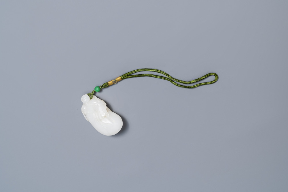 Un pendentif en jade blanc figurant un singe sur une pochette, Qing
