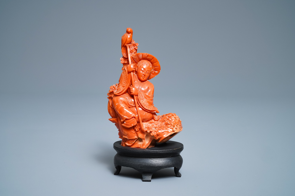 A Chinese carved red coral group of a boy with a parrot, 19/20th C.