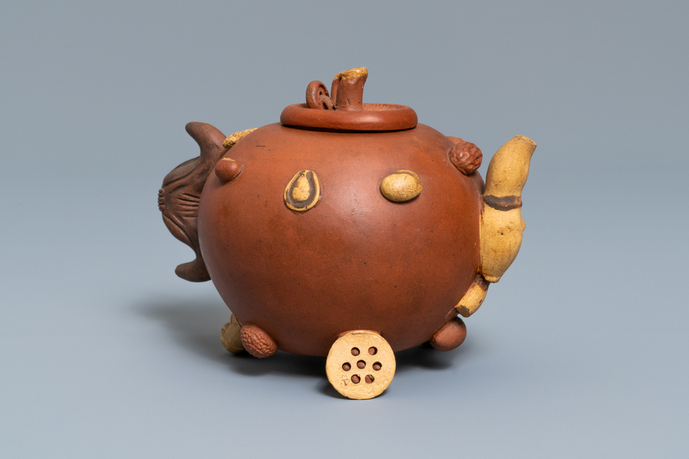A Chinese Yixing stoneware relief-decorated teapot with nuts and fruits, impressed mark, 19th C.