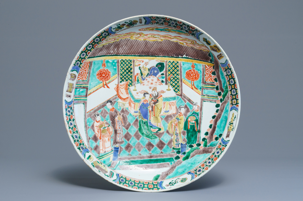 A Chinese famille verte charger with figures in an interior, Kangxi
